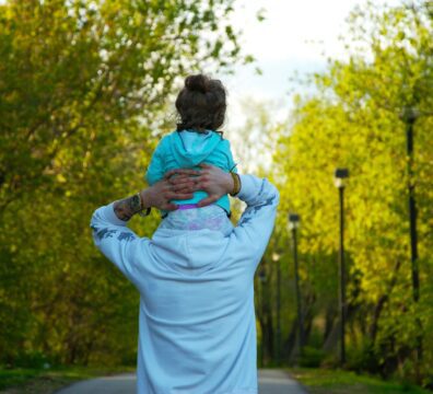 woman in white dress carrying baby in blue jacket